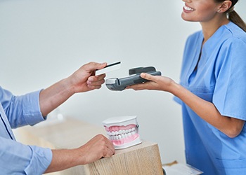 A patient paying the cost of dental implants