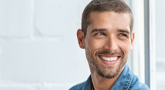 Close-up of a smiling man in a denim jacket