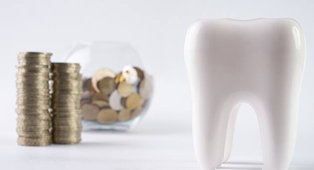 Tooth next to a pile of coins