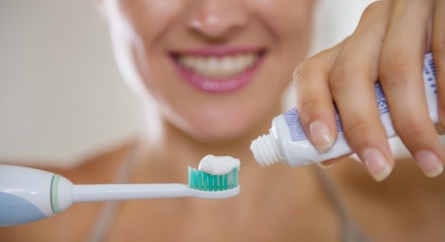 Woman brushing teeth to prevent gum disease