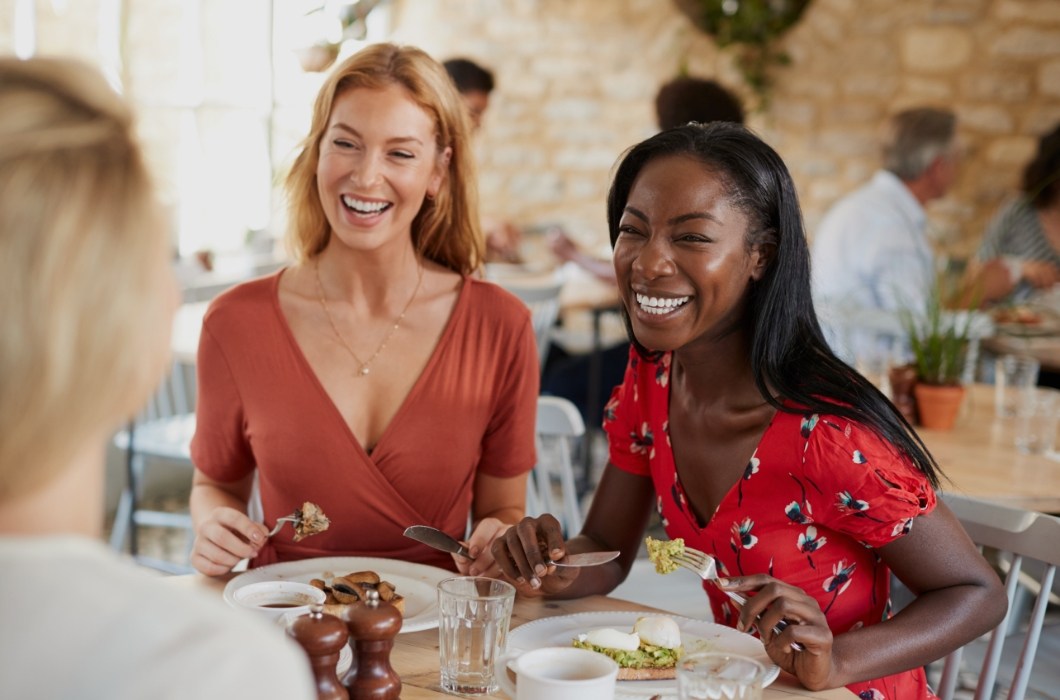 Two women laughing at table in restaurant