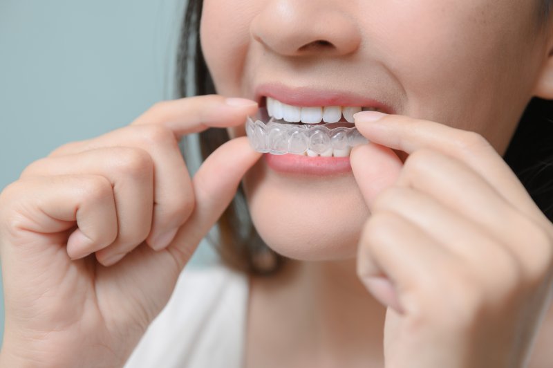 Woman holding her clear aligners